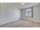 Empty bedroom featuring neutral walls, light wood flooring, and a large window at 8809 Beach Front Dr, Las Vegas, NV 89117