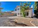 Two-story home featuring white stucco, clay tile roof, and sliding glass door to the yard on a sunny day at 8809 Beach Front Dr, Las Vegas, NV 89117