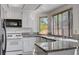 Granite counters, white appliances, and a large sink area overlooking the landscaped backyard at 8809 Beach Front Dr, Las Vegas, NV 89117