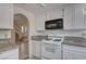 Kitchen area featuring white cabinetry and granite countertops with an open view to the front door and stairs at 8809 Beach Front Dr, Las Vegas, NV 89117