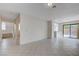 Spacious living room with tile floors, stairs to second level, and sliding glass door to backyard at 8809 Beach Front Dr, Las Vegas, NV 89117