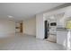 Living room adjacent to kitchen with white cabinets, stainless appliances, and tile floors throughout at 8809 Beach Front Dr, Las Vegas, NV 89117