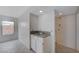 A utility sink is situated in the room with white walls, neutral flooring, and a window at 8809 Beach Front Dr, Las Vegas, NV 89117