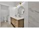 Stylish bathroom featuring a double vanity, sleek lighting, and a shower with marble-look tile at 8944 W Rochelle Ave, Las Vegas, NV 89147
