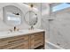 Modern bathroom featuring a double vanity, stylish mirrors, and a spacious shower with marble-look tile at 8944 W Rochelle Ave, Las Vegas, NV 89147