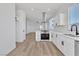 Bright kitchen showcases stainless hood, white cabinets, island with cooktop, quartz countertops, and durable wood-look floors at 8944 W Rochelle Ave, Las Vegas, NV 89147