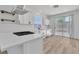 Bright kitchen features stainless hood, white cabinets, island with cooktop, quartz countertops, and access to the backyard at 8944 W Rochelle Ave, Las Vegas, NV 89147