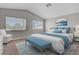 Virtually staged main bedroom featuring blue accents, vaulted ceiling, and large windows at 901 Carnival Ave, Las Vegas, NV 89123