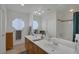 Bright bathroom features a double vanity, octagonal window, and a shower/tub combination at 9015 S Tenaya Way, Las Vegas, NV 89113