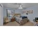 Cozy bedroom with a bed, chair, ceiling fan, and large window with natural light at 9015 S Tenaya Way, Las Vegas, NV 89113