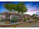 Landscaped exterior with decorative rock, mature trees, and brick accents provide curb appeal at 9015 S Tenaya Way, Las Vegas, NV 89113