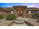 Inviting front entrance with concrete steps, rock details, arched entry, and a secure gated entry at 9015 S Tenaya Way, Las Vegas, NV 89113