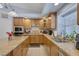 Well-equipped kitchen with wood cabinets, granite countertops, and modern appliances at 9015 S Tenaya Way, Las Vegas, NV 89113
