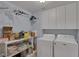 Functional laundry room with shelving, storage cabinets, washer, and dryer at 9015 S Tenaya Way, Las Vegas, NV 89113