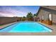 Sparkling in-ground pool surrounded by lush landscaping and a privacy wall at 9015 S Tenaya Way, Las Vegas, NV 89113