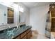 Bathroom featuring a granite counter, dual glass bowl sinks, and decorative mirrors at 902 Possum Hill St, Henderson, NV 89014