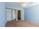 Bedroom with blue walls, closet organizer, ceiling fan, and neutral carpet at 902 Possum Hill St, Henderson, NV 89014