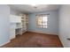 Spacious bedroom with brown carpet, a window, and built-in shelving at 902 Possum Hill St, Henderson, NV 89014