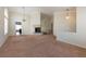 Open living room with a unique fireplace, neutral carpet, and large windows at 902 Possum Hill St, Henderson, NV 89014