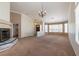 Spacious living room features a fireplace, neutral carpet, and an elegant chandelier at 902 Possum Hill St, Henderson, NV 89014