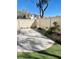 A low maintenance backyard featuring a concrete patio, artificial turf, and rock landscaping at 908 Shining Rose Pl, Henderson, NV 89052