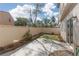 Cozy backyard featuring a concrete patio, small artificial lawn, rock details, and a light colored wooden fence at 908 Shining Rose Pl, Henderson, NV 89052