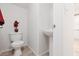 Compact powder room featuring a pedestal sink, toilet, and tiled flooring at 908 Shining Rose Pl, Henderson, NV 89052
