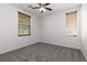 Bright bedroom featuring two windows, a ceiling fan, and neutral carpet at 908 Shining Rose Pl, Henderson, NV 89052