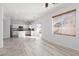Open-concept kitchen and living area with tile flooring, white cabinets, and stainless steel appliances at 908 Shining Rose Pl, Henderson, NV 89052