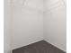 An empty walk-in closet with carpet flooring and white shelving for organized storage at 908 Shining Rose Pl, Henderson, NV 89052