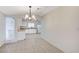 Bright dining area with tile floors next to kitchen with white cabinets and appliances at , Henderson, NV 89015