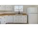 White kitchen features wood countertops, black hardware, and tile flooring at , Henderson, NV 89015
