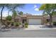 Inviting single-story home with a two-car garage, desert landscaping, and a tiled roof at 10017 Bundella Dr, Las Vegas, NV 89134