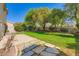Backyard features grassy lawn, mature trees, and a concrete patio at 10716 Aire Dr, Las Vegas, NV 89144