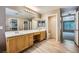 Updated bathroom with dual vanities, wood cabinets, and modern fixtures and flooring at 10716 Aire Dr, Las Vegas, NV 89144
