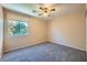 Neutral bedroom showcasing a ceiling fan, plush carpeting and bright window at 10716 Aire Dr, Las Vegas, NV 89144