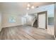 Open-concept living room with wood-look flooring, stairs to second floor, and lots of light at 10716 Aire Dr, Las Vegas, NV 89144
