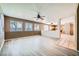Open concept living room with updated flooring, multiple windows, and neutral paint at 10716 Aire Dr, Las Vegas, NV 89144