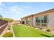 Well-maintained backyard with artificial turf, desert landscaping and a covered patio at 10890 Red Yucca Dr, Las Vegas, NV 89138
