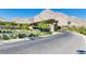 Community entrance featuring modern architecture, desert landscaping, and paved roads at 10890 Red Yucca Dr, Las Vegas, NV 89138
