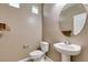 Powder bath with a pedestal sink, rounded mirror and sleek fixtures at 11063 Mount George St, Las Vegas, NV 89179