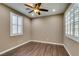 This bedroom has stylish dark wood floors, neutral paint, and crisp white windows with plantation shutters at 11063 Mount George St, Las Vegas, NV 89179