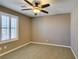 This carpeted bedroom features a ceiling fan and bright window with plantation shutters at 11063 Mount George St, Las Vegas, NV 89179