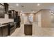 Open-concept kitchen featuring granite countertops, stainless steel appliances, dark cabinets, and tile floors at 11063 Mount George St, Las Vegas, NV 89179