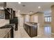 Open kitchen area featuring dark cabinets, stainless steel appliances, granite countertops, and tile flooring at 11063 Mount George St, Las Vegas, NV 89179