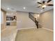 Open-concept living space with plush carpeting, staircase access, and a view into the modern kitchen at 11063 Mount George St, Las Vegas, NV 89179