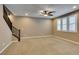 Bright and spacious living room with a ceiling fan, multiple windows, and comfortable carpeting at 11063 Mount George St, Las Vegas, NV 89179
