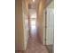 Hallway featuring tile floors, white doors, and lots of natural light from sliding glass doors at the end at 1174 Monogram Way, Las Vegas, NV 89123