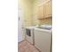 Light and airy laundry room features a washer, a dryer, cabinets and wire shelving at 1174 Monogram Way, Las Vegas, NV 89123