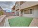 Enclosed backyard with small turf and an AC unit on a small patio at 11904 Glide Reflection Ave, Las Vegas, NV 89138
